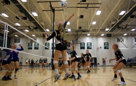 Senior Sydney Moreano and sophomore Payton Gannaway jump to block a spike from Bishop Miege during a match on Oct. 15.