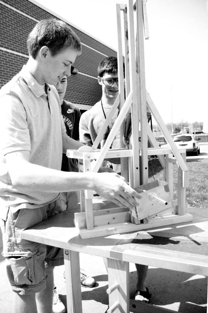 Below, seniors from an Industrial Design class demonstrate how to use a trebuchet (catapult) that they built. Photo by Megan Engleman.