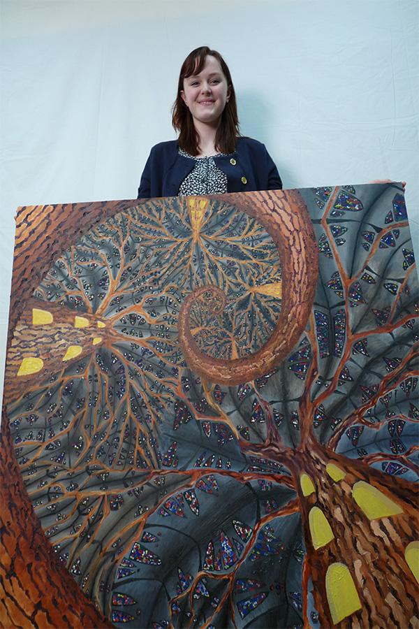 Anna Cormack poses with one of her many art pieces Trees and Cathedral. 