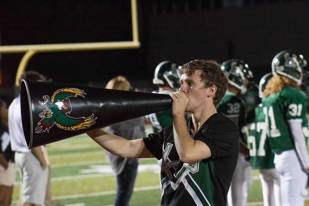 Junior Brandon Wilson chants through his megaphone during a Friday night football game.