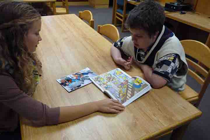 Reporter Fiona McAllister reads a Simpsons comic book with freshman Benji Horton.