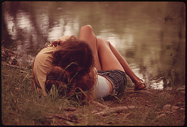 Two teens kiss on a river bank in 1973.