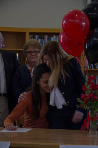 Alexa Harmon-Thomas embraces her mother after signing her letter of intent to run track at the University of Texas at Austin.