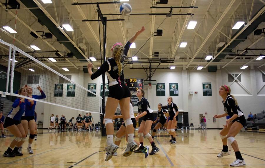 Senior+Sydney+Moreano+and+sophomore+Payton+Gannaway+jump+to+block+a+spike+from+Bishop+Miege+during+a+match+on+Oct.+15.