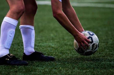 Varsity soccer player places the ball for a penalty kick at a home game during the fall season.