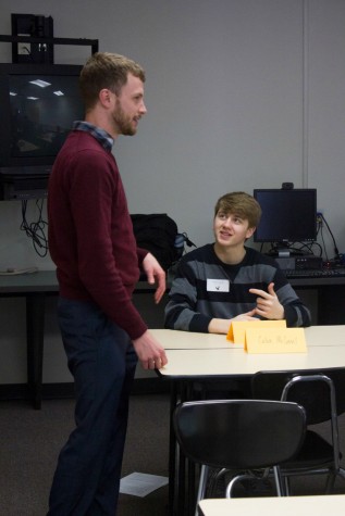 Waiting for the meeting to begin, sophomore Drake Calub talks with Calvin McConnell, assistant director of freshman recruitment at the University of Kansas, The lunch meeting took place on Jan. 28 in the library classroom and the Commons. "[The program] is a great way to expand [our] varieties on what [we] want to do in the future," Calub said. 