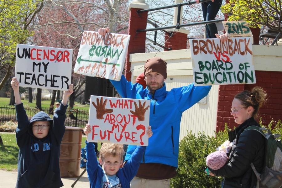 Participants in Lawrences Rally for Kansas Schools hold signs in protest of recent legislation, such as the block-funding grant, which will cut an estimated $1.98 million from the Lawrence school district. I think this has been really great to spread awareness, Johnson County resident Erin Heger said.