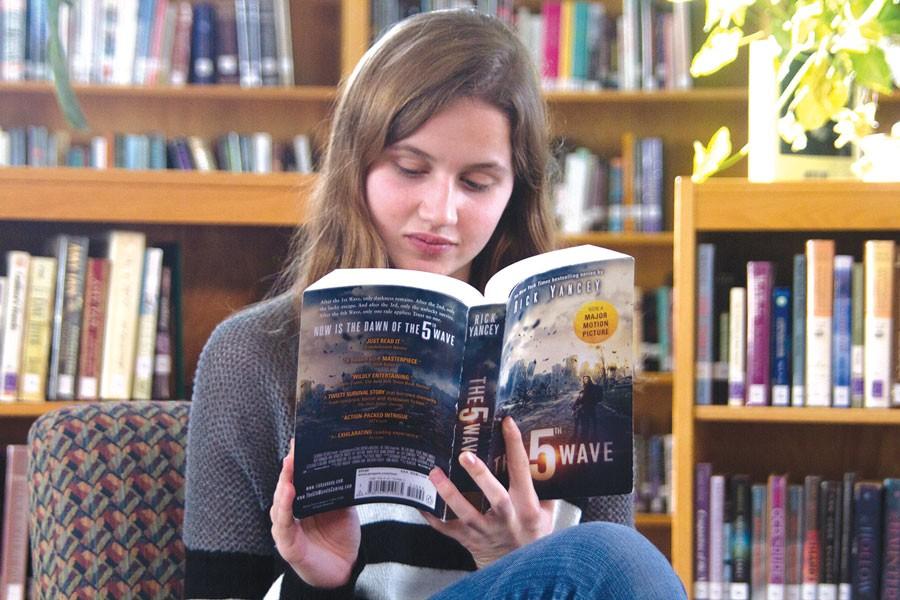 Sitting silently in the library, sophomore Reagan Sullivan reads The 5th Wave.