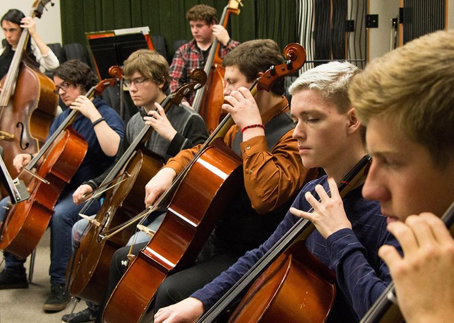 Making music, sophomore Teagan Ryan plays his cello alongside his classmates. Ryan is in concert orchestra, under the direction of one of the new music teachers, Mr. Shaw. Its a lot of fun, hes really nice, Ryan said.