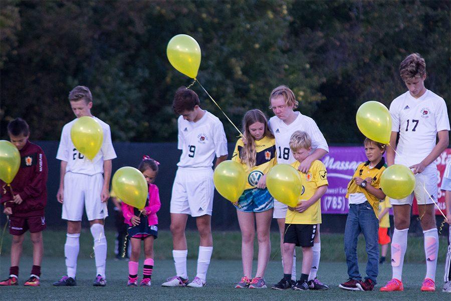 Freshmen Pete Jung, junior Jared Lieberman, senior Owen Kapfer and senior Tom Reno all bow their heads for a moment of silence. “I know she’s watching over me, Kapfer said.