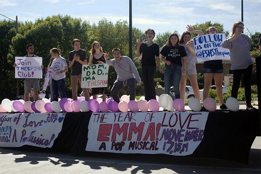 Eli Bork, Anna Bial, Chris Pendry, Morgan McReynolds, Ilya Schaeffer, Calliope Taylor, Rheanne Walton, Anina Supernaw, Helena All, Eliza Hasse-Divine hold signs and cheer towards spectators during the homecoming parade. There were hundreds of spectators during this years parade.