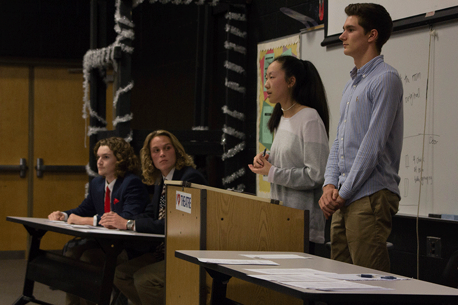 Erb and Flynn watch Shi and Pultz-Earl present their argument on student debt.