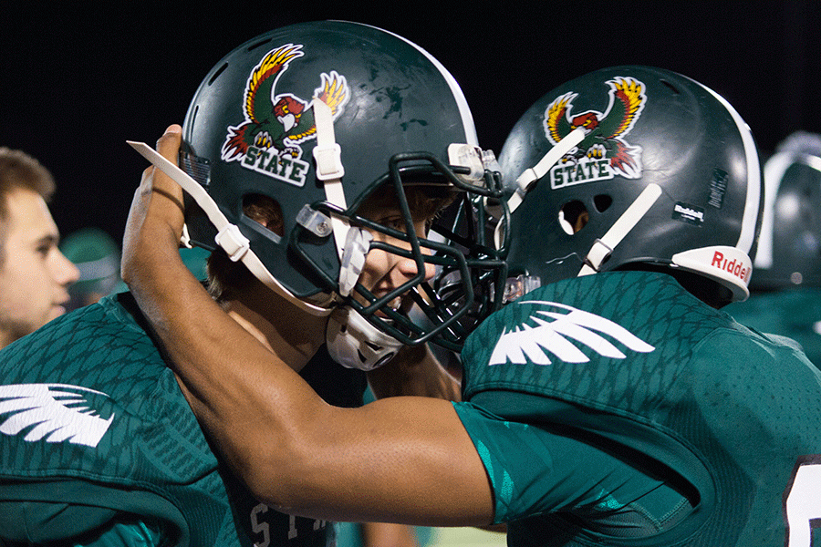 In celebration, senior Zion Bowlin hugs sophomore Kameron Lake. Lake kicked the winning field goal against Washburn Rural