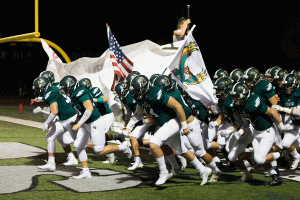 At the start of the game, the firebird football team runs through their banner. The team won in the quarterfinals 17-14.