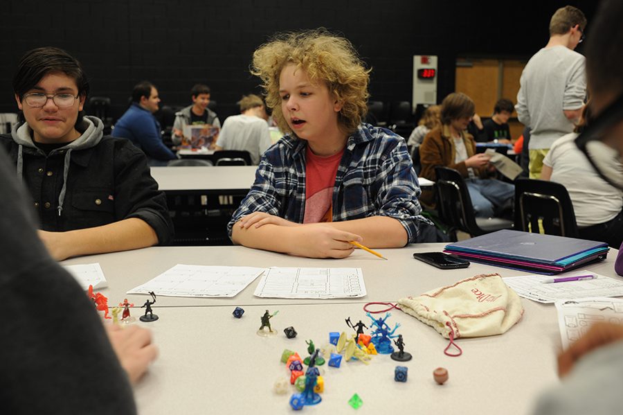 Filling out his custom character sheet, junior Max Coleman discusses strategy with his team mates. 