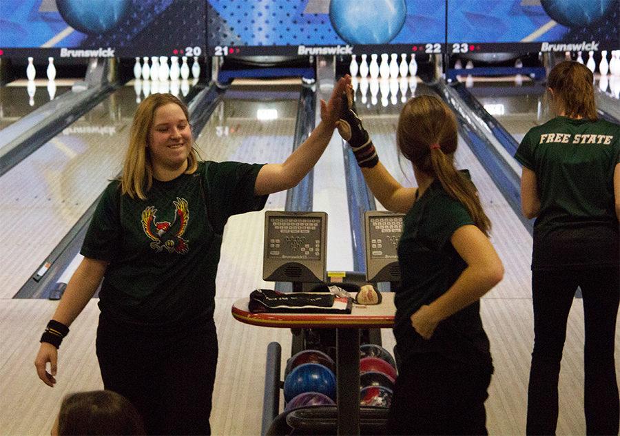 High fiving her teammate, Sapphira Knight celebrates after bowling a strike. Knight is on the girl’s varsity bowling team this year and has been bowling through Free State for three years now. “I think meeting new people [is my favorite part about] each tournament we go to. There’s like six people on each team, so you get to meet six new people you bowl with,” Knight said.