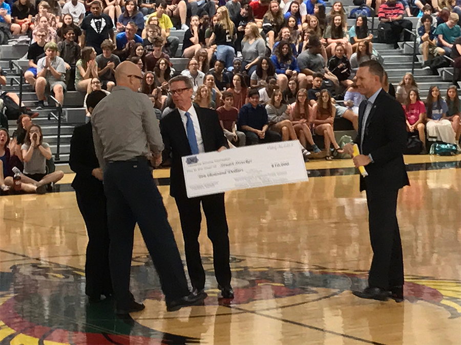 Stuart Strecker receives the $10,000 check from Lawrence Schools Foundation board of directors president Scott Morgan. This year is the Bobs Award twentieth anniversary. 