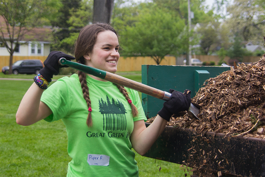 Shoveling mulch, junior Piper Rogers fills up wheel barrells to be carried to flower beds. Around 100 juniors volunteered for Great Green Help. “My favorite part was seeing all of the smiles and hard work that people put in despite the rain,” Rogers said.