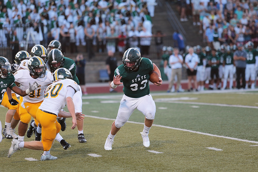 Junior Jax Dineen tries to avoid his opponent. Dineen scored multiple touchdowns.