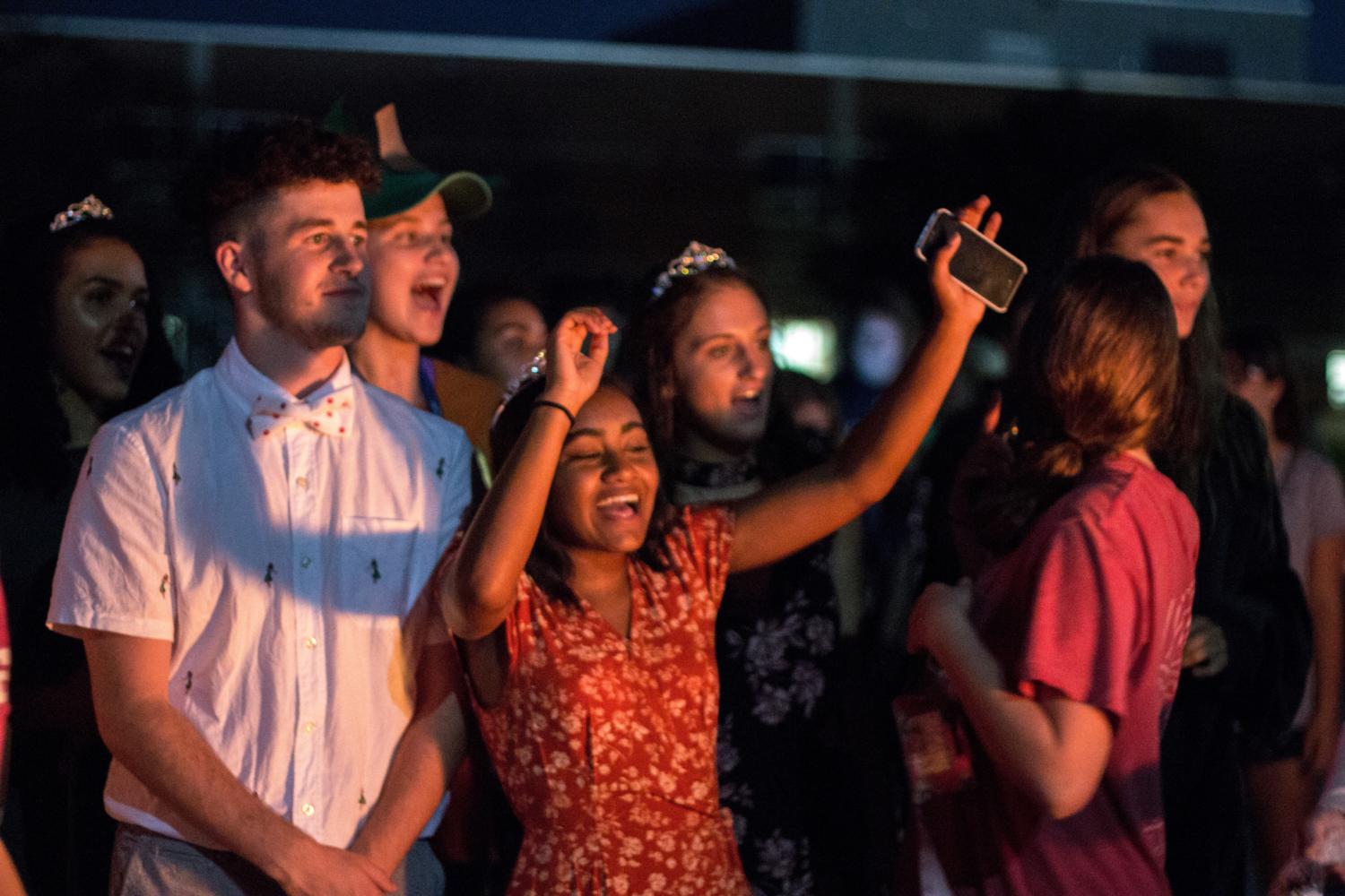 Homecoming candidates Simone McCaffrey and Maya Hodison cheer on a peer who is lighting the fire. At this point in the night the fire had not diminished.