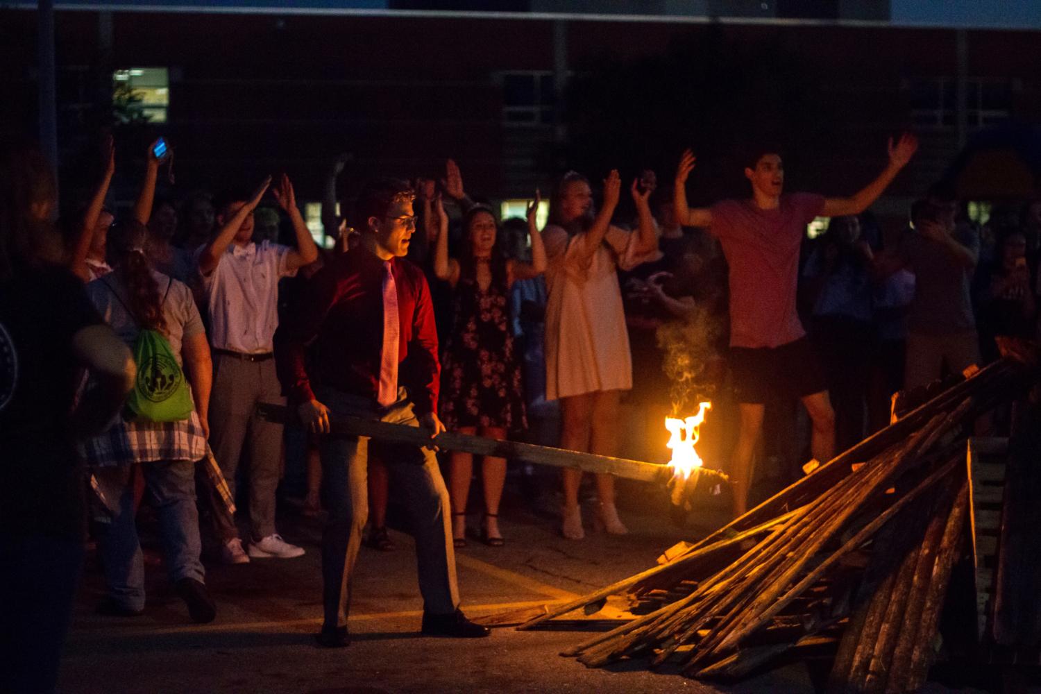 Homecoming candidate Teddy Carttar attempts to light the fire. Due to the wood being wet, the fire was unable to remain lit.   