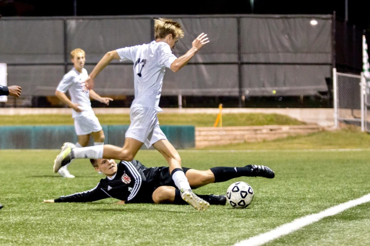 Junior Landon Sloan avoids slide tackle from opposing defender. Sloan was out in the first overtime due to a cramp in his leg. 