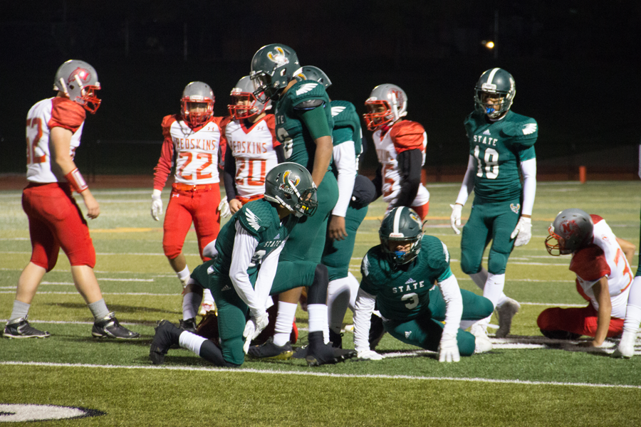 Junior Matt Georgie jumps back to his feet with his team after a play. The Firebirds scored 35 points in the first quarter.