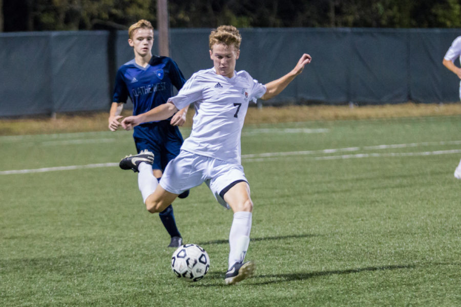 With force, junior Pete Junge kicks the ball down the field. Junge recently recovered from a concussion received during the game against SMW.  