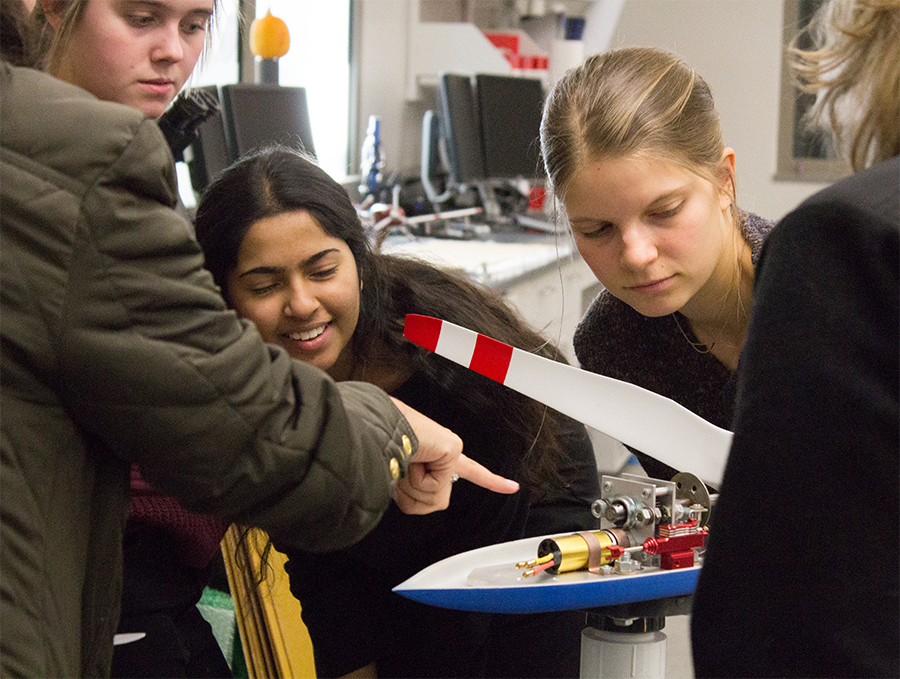 Ascent club members are shown a model wind turbine during a field trip.