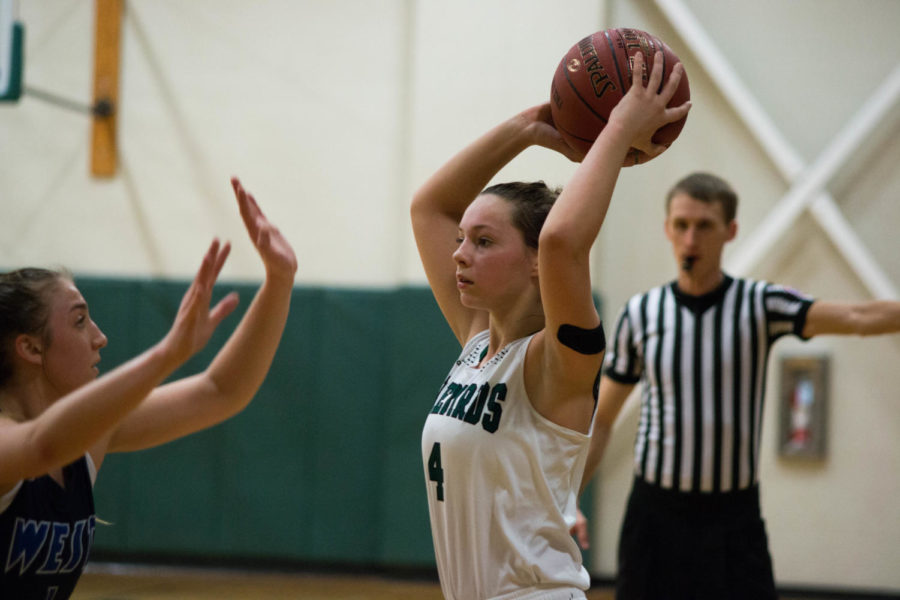 Holding the ball away from an opponent, junior Sam Lawrence finds a teammate to pass the ball to. Lawrence plans to play basketball in college. You understand what its like to be a leader or just being apart of a team, Lawrence said.