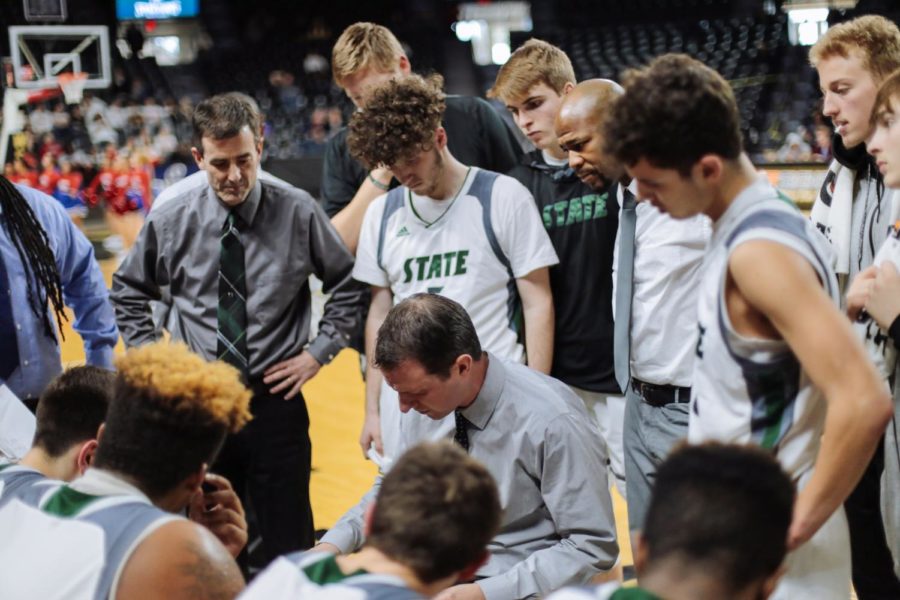 With players and coaches gathered around, boys basketball coach Sam Stroh discusses strategies for the fourth quarter. Simon McCaffrey hit two free throws at the end of the game to help ensure Free State finished with a win.