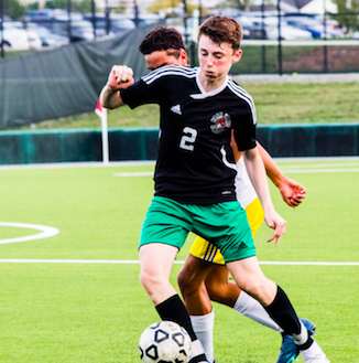 Trying not to let his opponent steal the ball from him, sophomore Zach Geortzen takes the ball further down the field. Everyone is staying focused and prepared to make it to the state final, said Geortzen. There are several more games that will determine if they get to compete in the state final. 