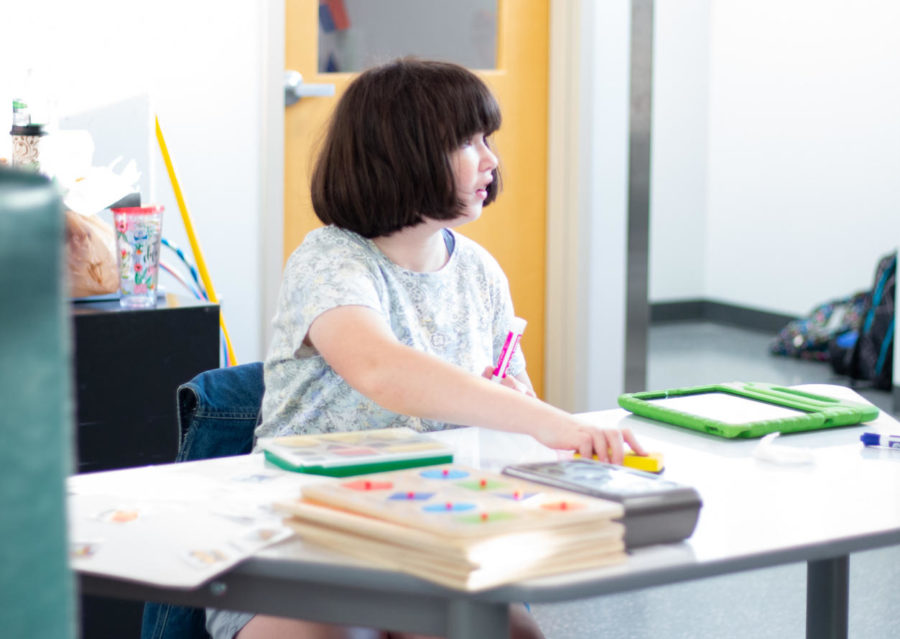 Freshman Emma Joseph writes on a new desk. Teachers feel the transition in space has been positive but challenging. “The space was not designed to be a special education classroom.” SpEd teacher Marie Wheeler said. “We had to be super creative with where we were setting up work stations.”