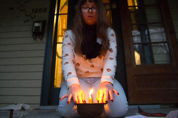 After dressing and lighting the candle, Pratt places their hands on the cauldron and concentrates on their intent to be happy. 