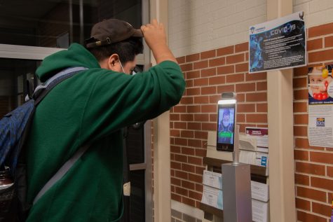 A student checks their temperature in the front office so they can be cleared to enter the school and start their day. At the beginning of each day, every student is required to check their temperature to ensure that students are staying healthy. There is least one temperature station per entrance to make sure all students are checked in before they enter the building.

