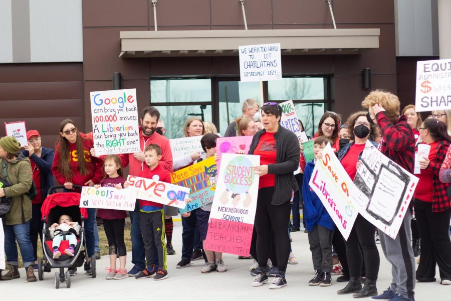 People gather outside of district office to protest possible library staff cuts.