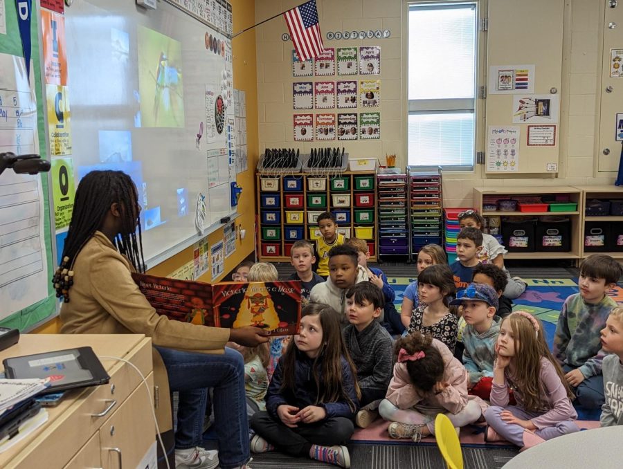 Senior Wendo Kimori reads to children. Photo submitted by Wendo Kimori.