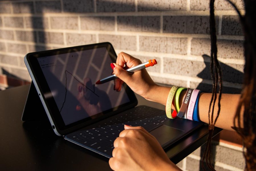 Senior Ashanti Riccardo draws on an iPad using a pen. Next year, students will be given a pen along with their iPad to allow similar functionality.