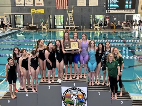 Seniors Bradie Ward and Samantha Packard hold the 6A first place trophy with their teammates around them. As of this Saturday, both Packard and Ward are back-to-back state champions. Photo contributed by Free State Swim and Dive.