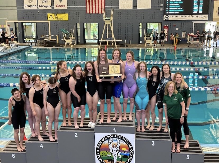 Seniors Bradie Ward and Samantha Packard hold the 6A first place trophy with their teammates around them. As of this Saturday, both Packard and Ward are back-to-back state champions. Photo contributed by Free State Swim and Dive.