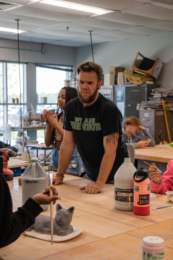 Listening to his students, ceramics teacher Byran Lloyd helps them pick a color for their project. “Something that’s been very rewarding is hiring about students going into art education or knowing that students have a great sense of satisfaction from making with with clay,” Lloyd said. 