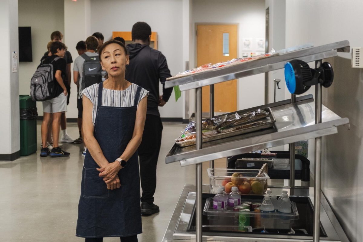 Waiting patiently, Cafeteria worker Ikuko Fox watches hungry students grab their second chance breakfast. Ms. Fox works at the Second Chance Breakfast cart at the end of the 2nd floor hallway.