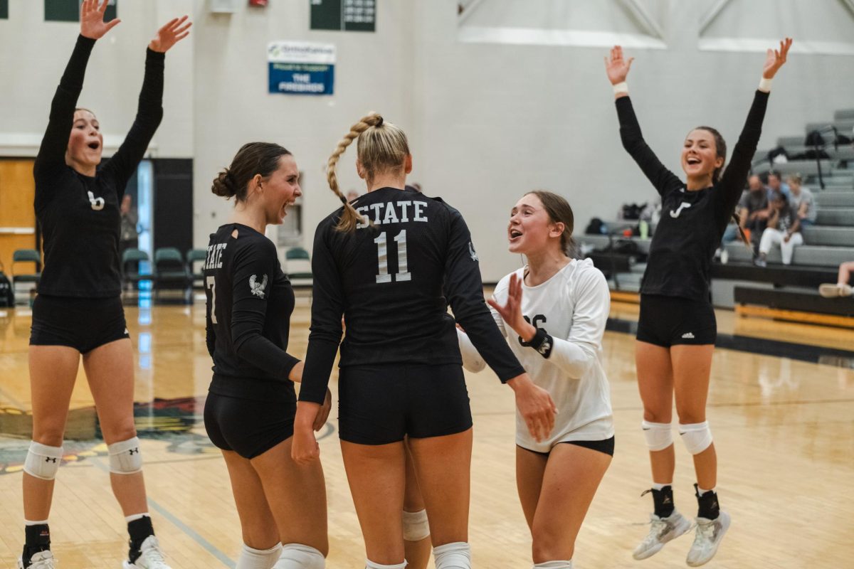 After a block, senior Fiona VanDyke’s teammates cheer her on. VanDyke is a returning member to the Varsity Volleyball team this year. 
