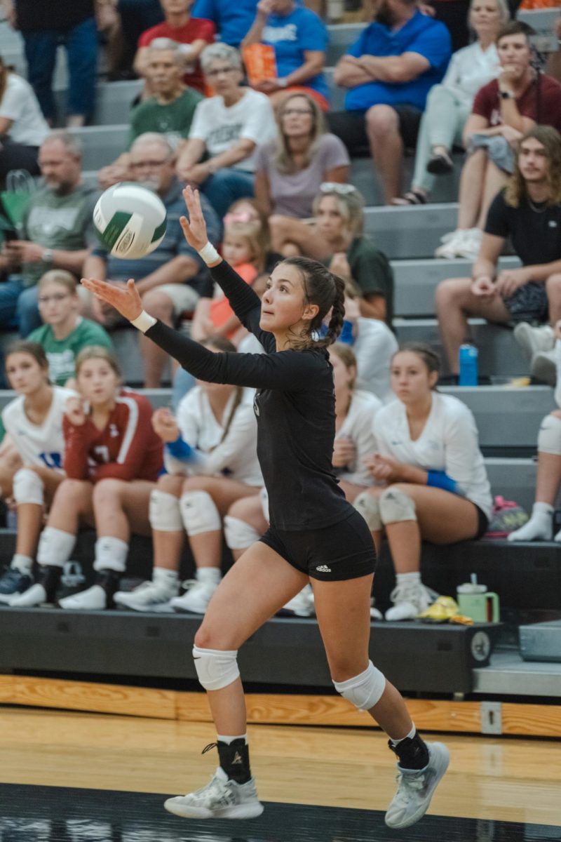 Tossing the ball, senior Ryan Morgan puts up a serve against the opposing Seaman High School Vikings. This was the varsity team’s first game of the season. “I was excited for my first Varsity match. Being able to be the first server was exhilarating and we were ready to play” Morgan said.
