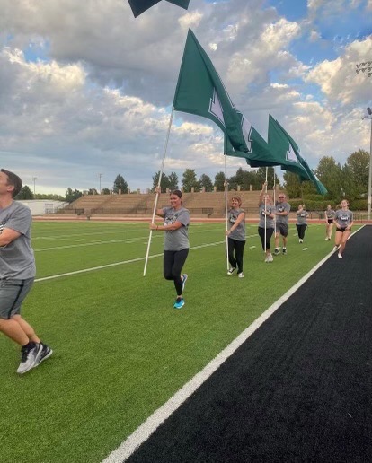 Parents of the cheer team run with state flags at cheers Parent Boot Camp on Sept. 26. Photo courtesy of Ellie Trummel