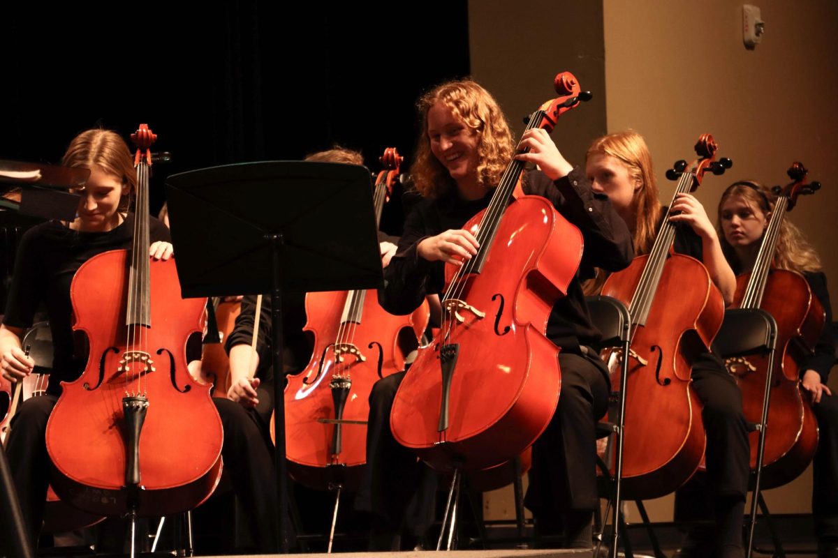  Laughing, senior Elliot Storm plays the cello with the rest of the chamber orchestra at the fall concert. Photo Courtesy of Cooper Stone. 