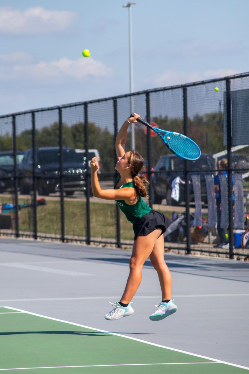 Sophomore Cami Lee hits tennis ball at a varsity tennis meet. Cami Lee started playing with her older sister, senior Maya Lee, 5 years ago.