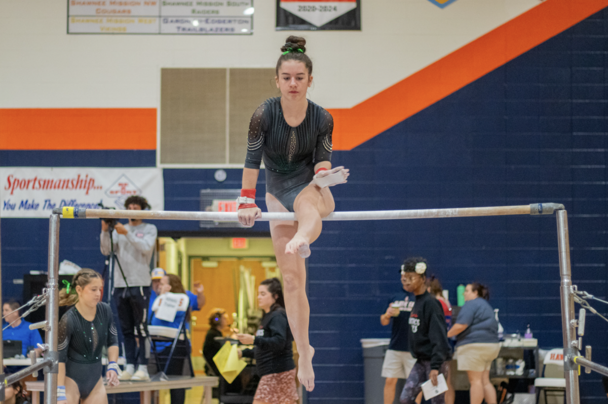 At a gymnastics meet at Olathe East on Sept. 23, junior Anne Cross performs her bar routine. 