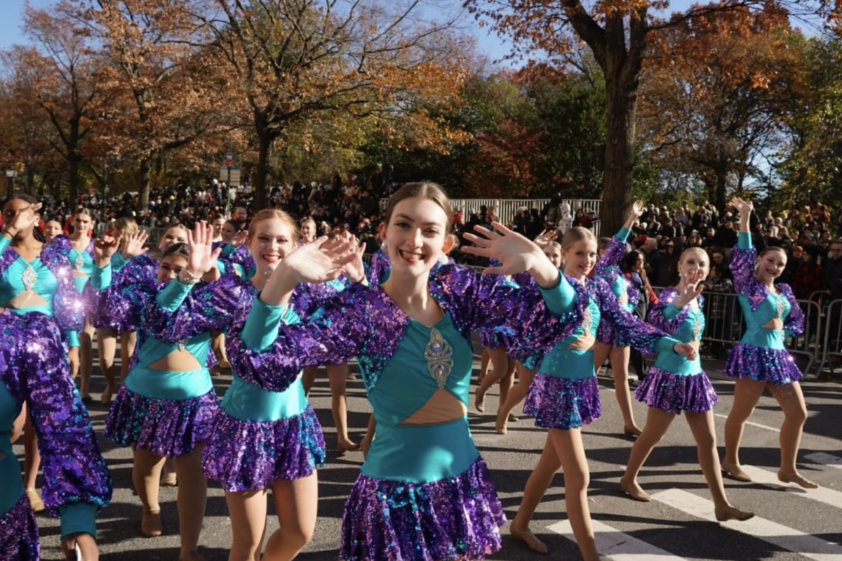 Smiling in the street, junior Olivia Hemker is surrounded by hundreds of other Spirit of America dancers from across the country. Photo collected from Olivia Hemker.