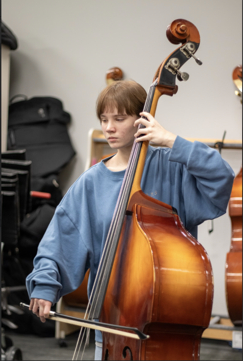 Bowing a bass, senior Sawyer Janssen practices for all-state auditions. Getting the results back, Janssen placed 6th in the state on double bass. “I really enjoy playing music,” Janssen said. “I love the sound of string instruments and classical music.”